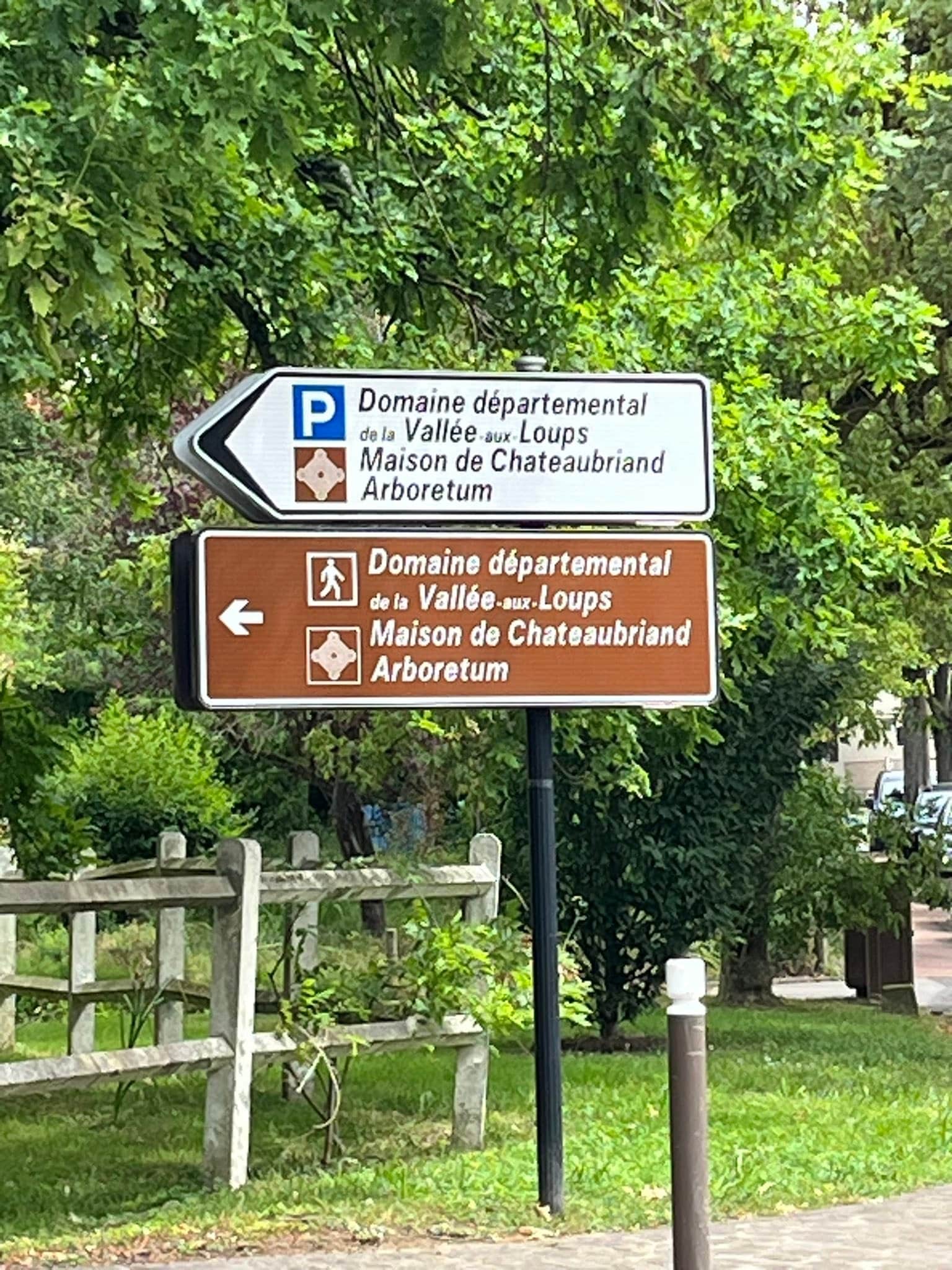 712644405_1291533036467853_2536232627121092381_n Directional sign pointing toward Domaine départemental de la Vallée-aux-Loups and Arboretum (Maison de Châteaubriand) in a green park setting