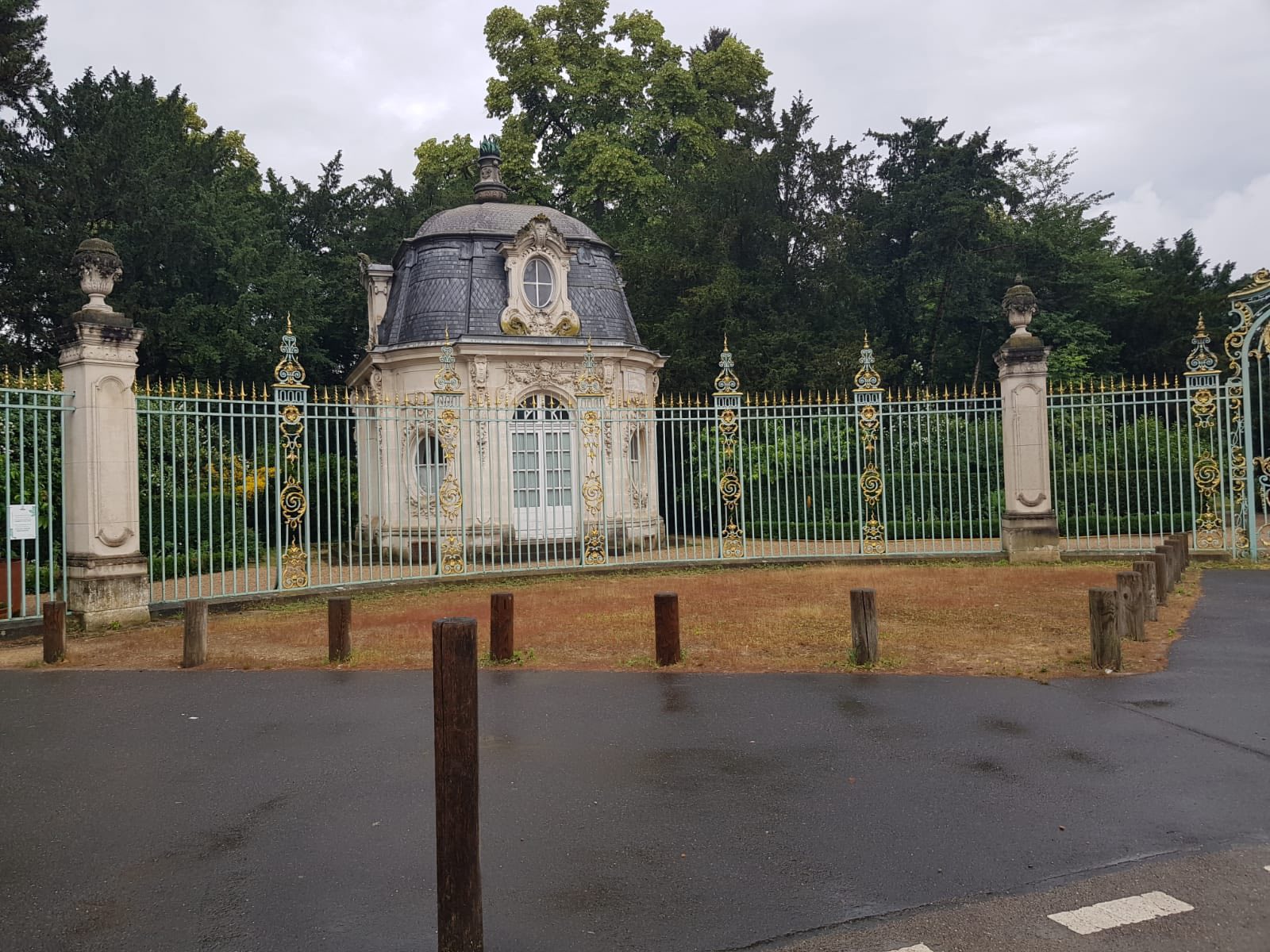 713543789_1290691976551959_2914028682748205795_n Elaborate domed garden pavilion behind a tall ornamental fence with gold detailing in a park setting.