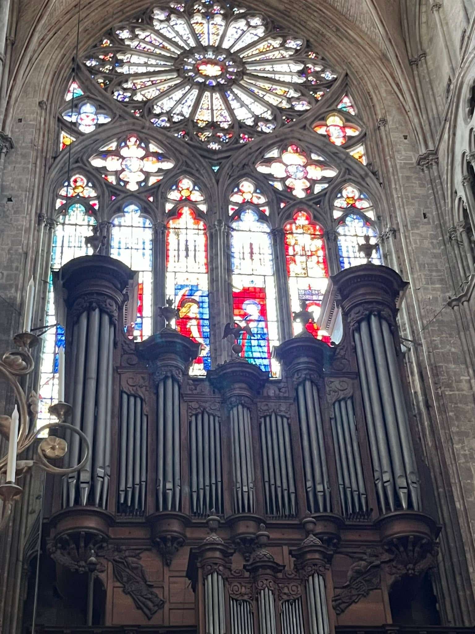 726704729_1305298155091341_181969880914525288_n Cathedral interior with a large circular stained-glass rose window above an ornate organ and stone arches.