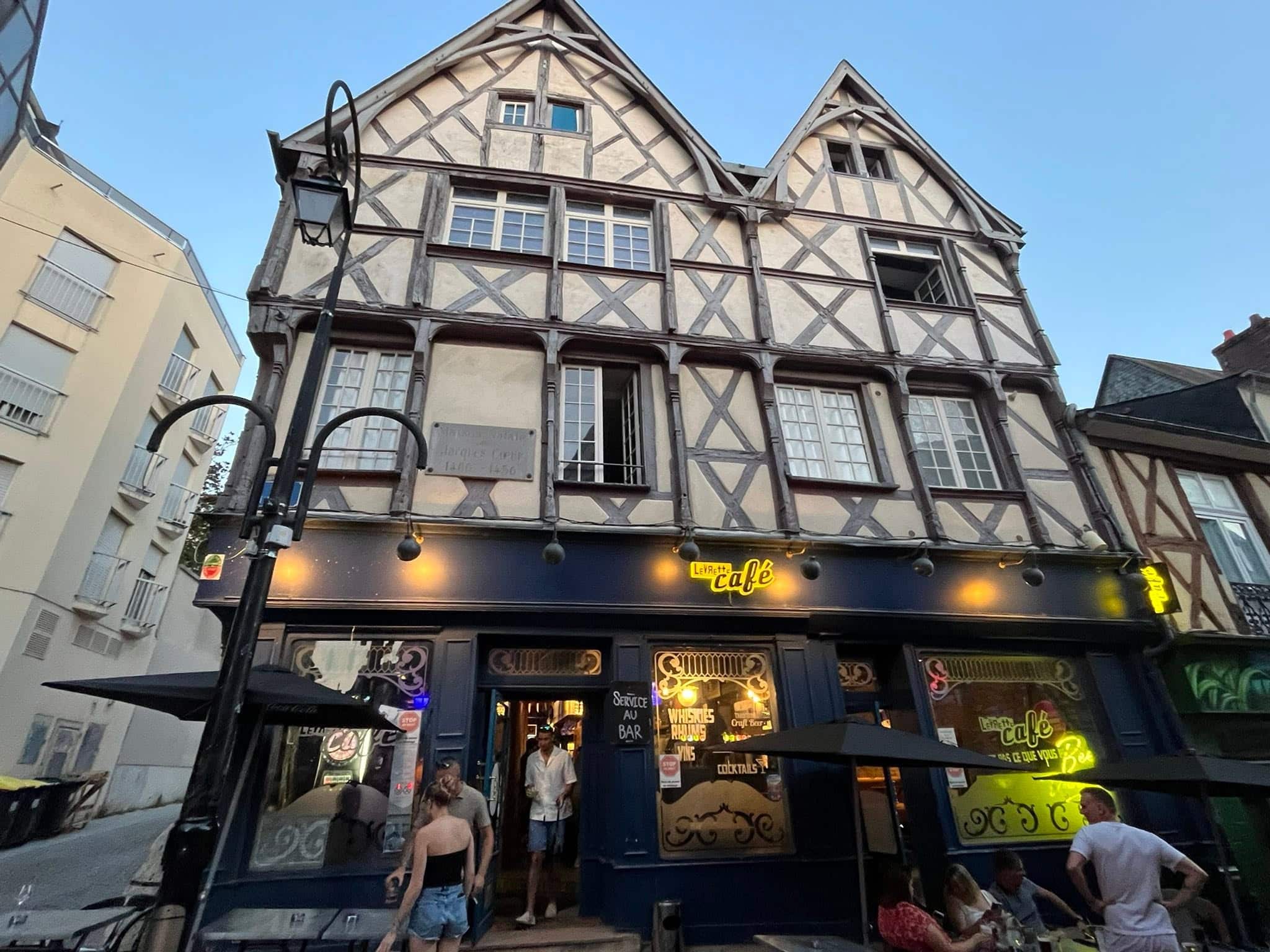 726717248_1305299651757858_2200065856607282480_n Historic timber-framed building housing a cafe, with outdoor seating and warm lights outside.