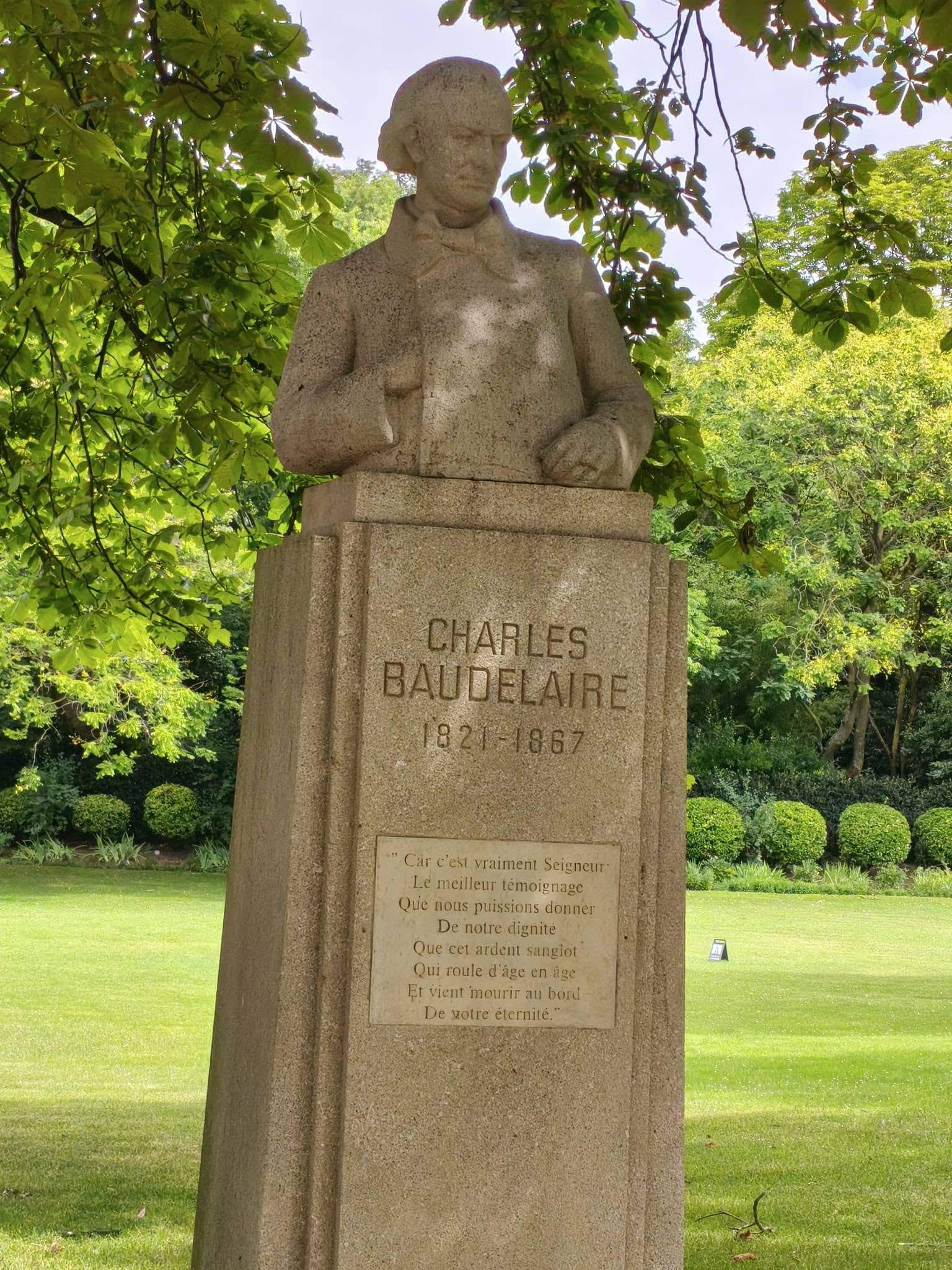 735034521_27010046662028849_424123501918854277_n Stone bust of Charles Baudelaire on a pedestal in a green park; inscription reads 'Charles Baudelaire 1821-1867'.