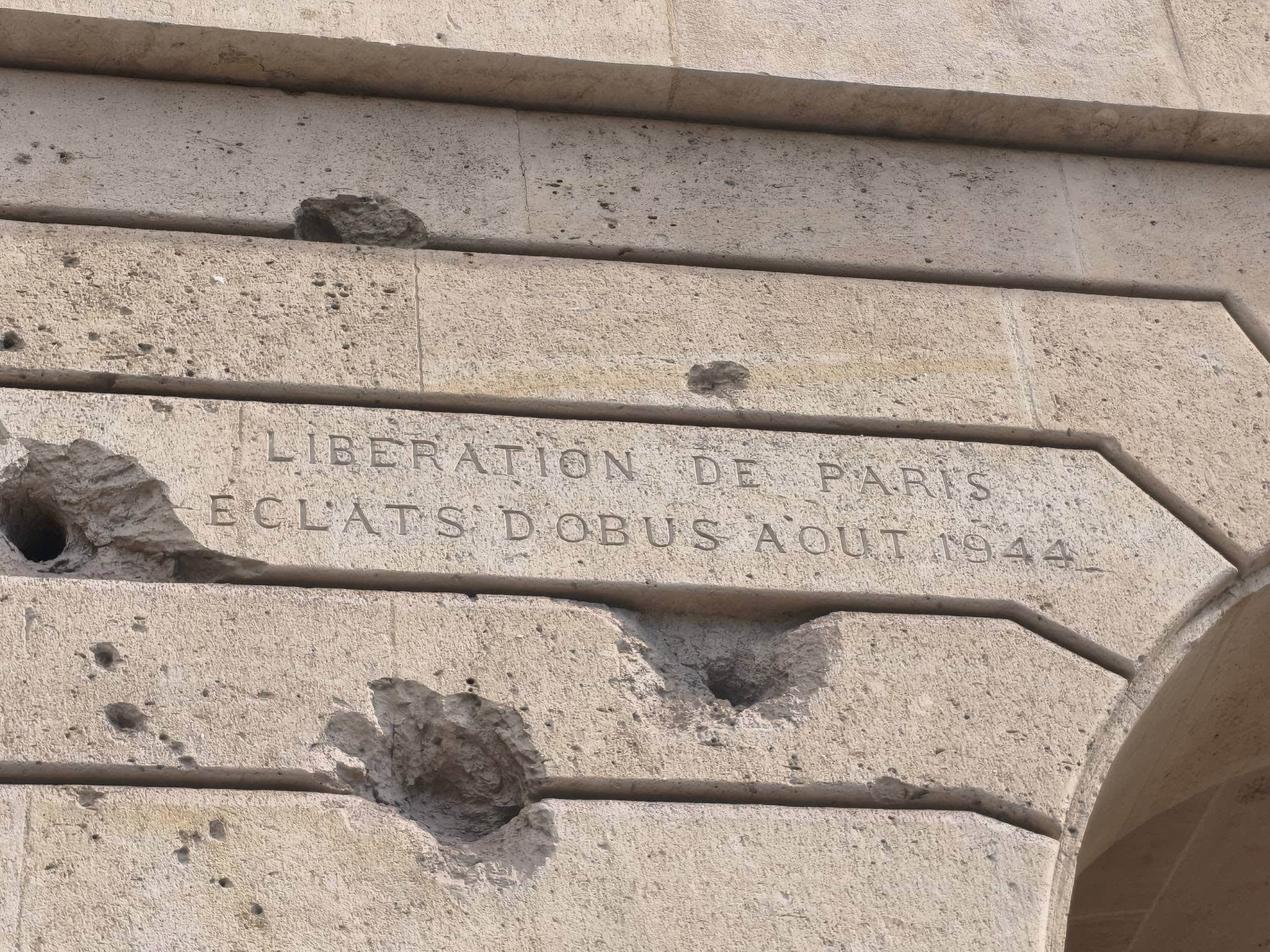 735625227_27010037722029743_2219936210603076992_n Close-up of a weathered stone wall with an engraved French inscription reading 'LIBERATION DE PARIS' (partially obscured).